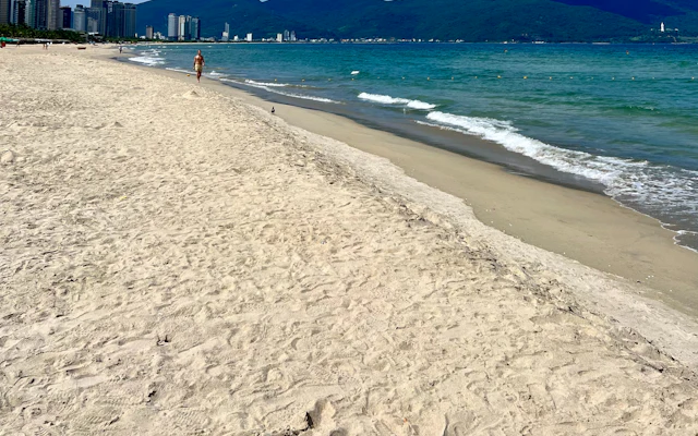 Ein Strand mit einer Stadt im Hintergrund