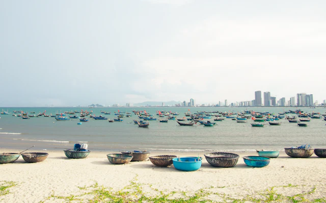 Boote säumen die Meeresküste in der Nähe der Skyline einer Stadt
