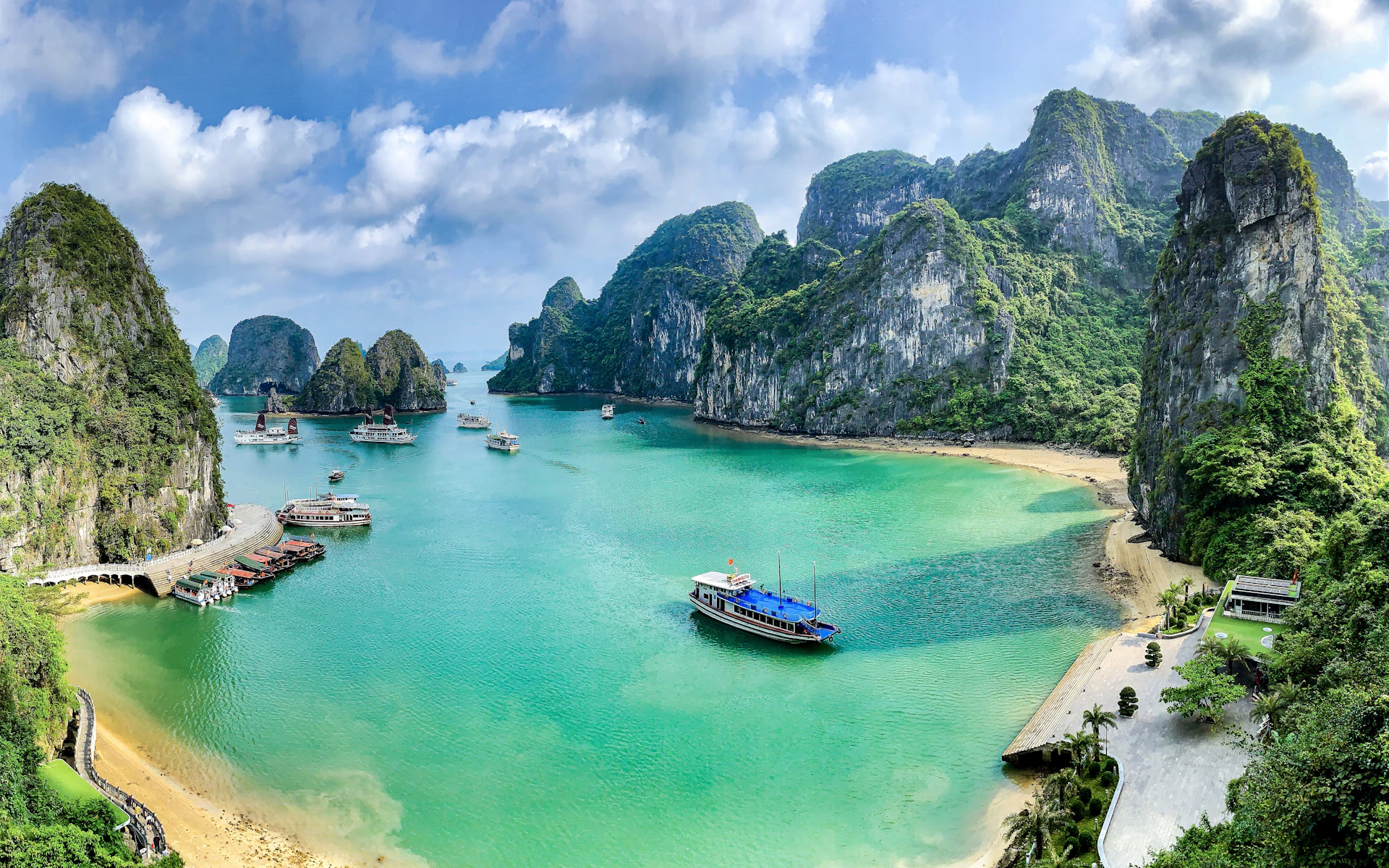Boote auf dem türkisfarbenen Wasser der Ha Long Bay, umgeben von Kalkstein-Karstinseln