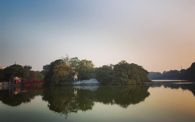 Ruhige Wasserfläche und Baumreihen in Hanoi