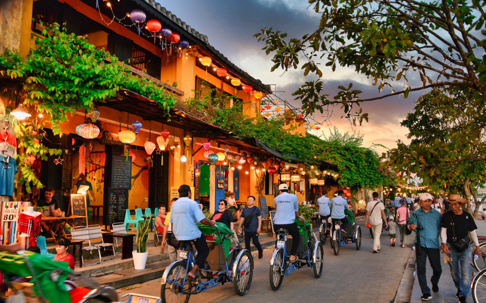 Radfahrer zwischen beleuchteten Häusern und Laternen in Hoi An