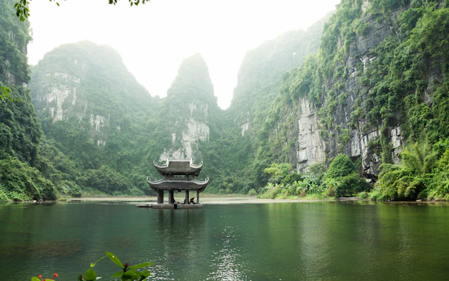 Pavillon am Wasser vor den Kalksteinfelsen von Ninh Binh