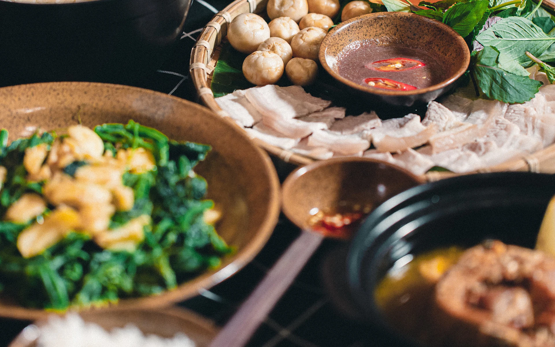 Vietnamesische Gerichte mit Kräutern und verschiedenen Beilagen