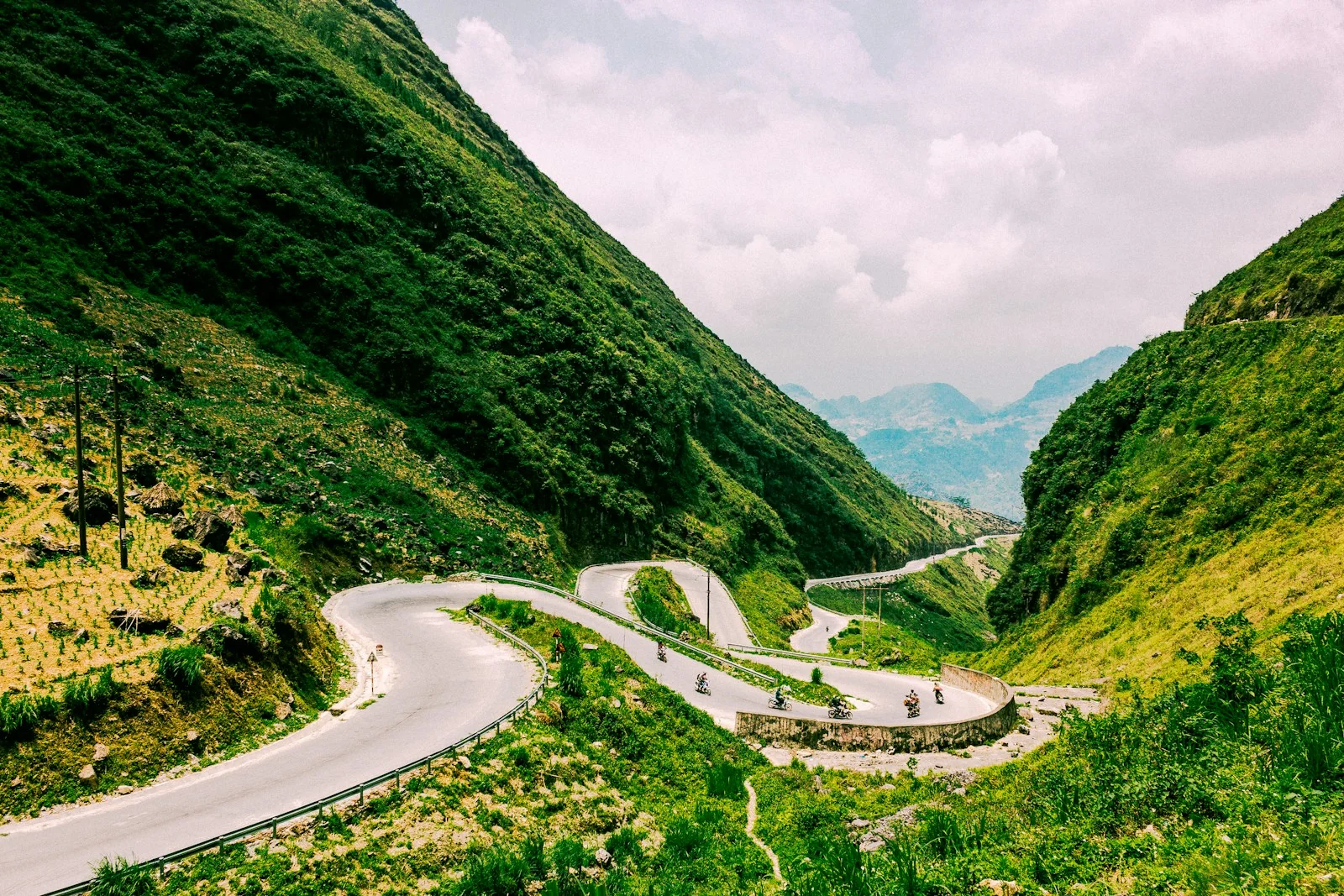 Grüne Berghänge und Serpentinen am Tham-Ma-Pass auf dem Dong-Van-Karstplateau